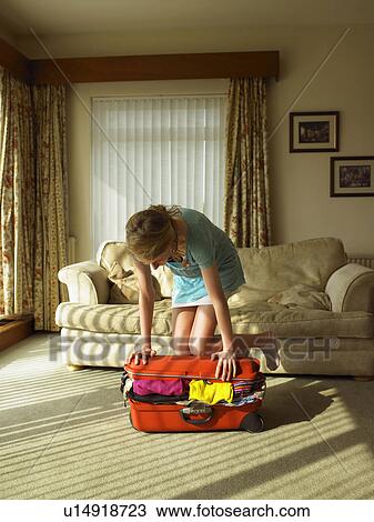 Young female trying to close suitcase View Large Photo Image Stock Image - Young female trying to close suitcase. Fotosearch