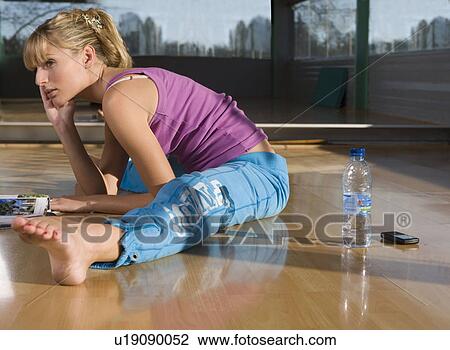 Young woman stretching in a gym View Large Photo Image Stock Image - Young woman stretching in a gym. Fotosearch