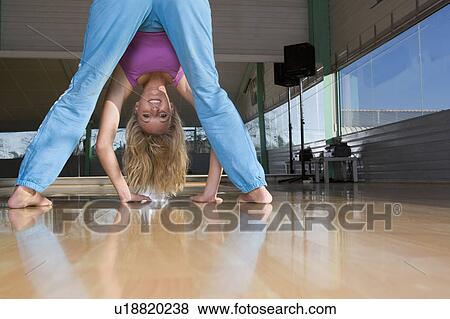 Stock Photo - Young woman stretching in a gym. Fotosearch