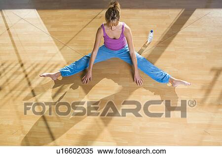 Young woman stretching in a gym View Large Photo Image Stock Photography - Young woman stretching in a gym. Fotosearch