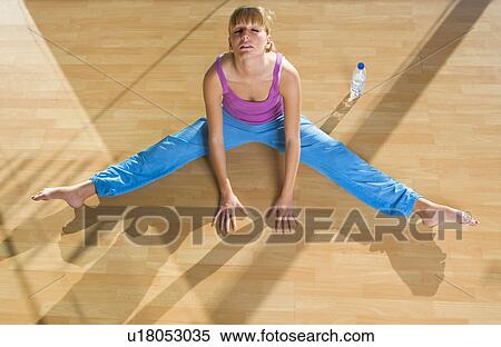 Stock Photography - Young woman stretching in a gym. Fotosearch