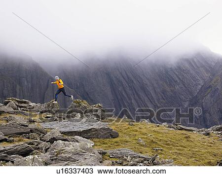 Man jumping off rock. View Large Photo Image Stock Image - Man jumping off rock.. Fotosearch
