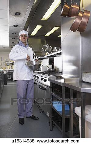 Stock Photo - Chef beating food in bowl in kitchen. Fotosearch