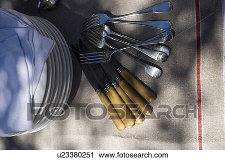 Stock Image - Cutlery and plates on linen . Fotosearch