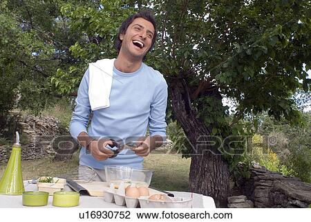 Young man preparing food View Large Photo Image Stock Image - Young man preparing food. Fotosearch