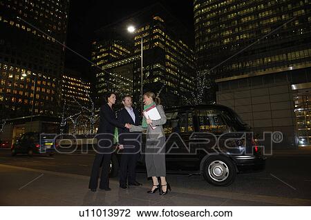 Stock Image - Business trio with taxi and office block. Fotosearch