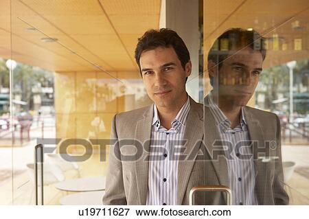 Businessman reflected in glass door of a café, portrait. Alicante, Spain. View Large Photo Image Stock Photo - Businessman reflected in glass door of a café, portrait. Alicante, Spain.. Fotosearch