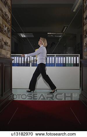 Businesswoman in a hallway with binders View Large Photo Image Stock Image - Businesswoman in a hallway with binders . Fotosearch