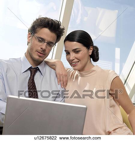 Couple looking at laptop View Large Photo Image Stock Image - Couple looking at laptop. Fotosearch