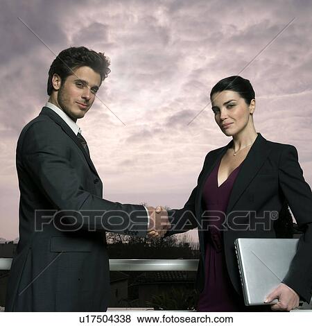 Stock Photo - Couple outdoors, shaking hands. Fotosearch