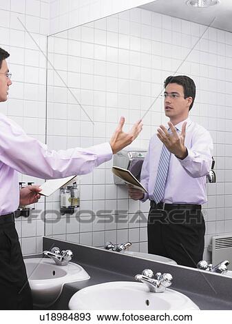 Man practicing speech in office washroom mirror View Large Photo Image Stock Image - Man practicing speech in office washroom mirror. Fotosearch