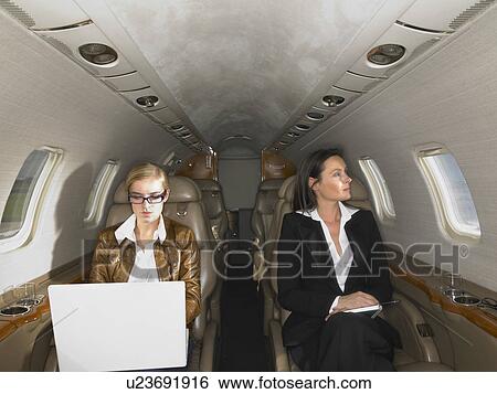 Two women in a private jet. View Large Photo Image Stock Photograph - Two women in a private jet.. Fotosearch