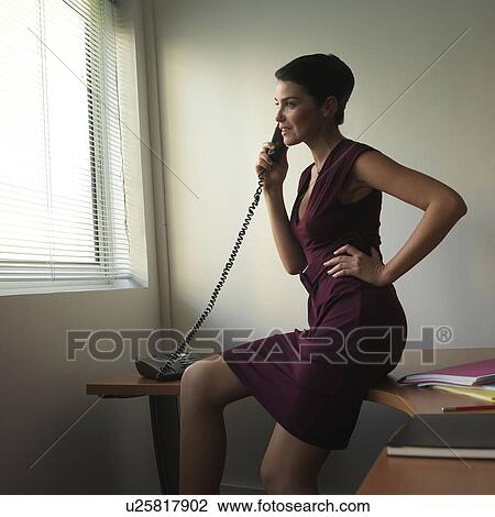Woman on desk, using phone in office View Large Photo Image Stock Image - Woman on desk, using phone in office. Fotosearch