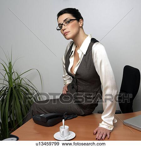 Woman sitting on desk, portrait View Large Photo Image Stock Photo - Woman sitting on desk, portrait. Fotosearch