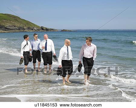Stock Image - Group of businesspeople on the beach.. Fotosearch