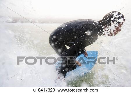 Man on surfboard splashing water. View Large Photo Image Stock Image - Man on surfboard splashing water.. Fotosearch