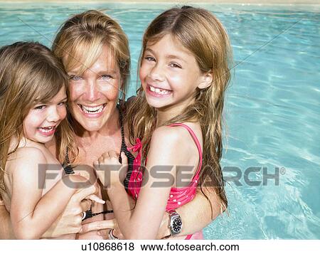 Stock Photo - Mother and daughters in pool.. Fotosearch