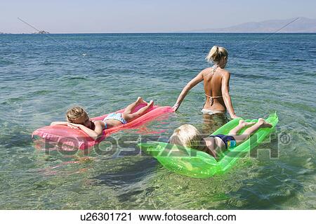 Woman pulling young boy and young girl on inflatable rafts. View Large Photo Image Stock Image - Woman pulling young boy and young girl on inflatable rafts.. Fotosearch