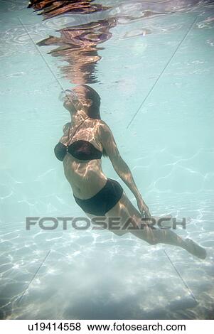 Woman swimming underwater View Large Photo Image Stock Photo - Woman swimming underwater. Fotosearch