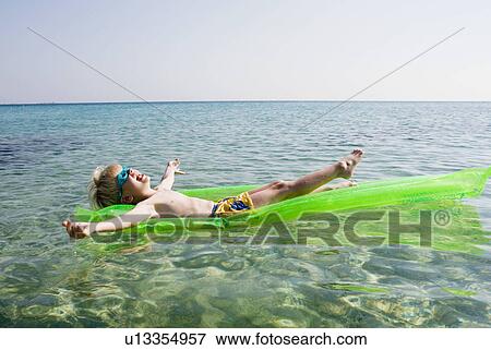 Young boy on an inflatable raft in the water smiling. View Large Photo Image Stock Photo - Young boy on an inflatable raft in the water smiling.. Fotosearch