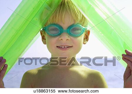 Young boy wearing swim goggles and holding an inflatable raft over his head. View Large Photo Image Stock Photography - Young boy wearing swim goggles and holding an inflatable raft over his head.. Fotosearch