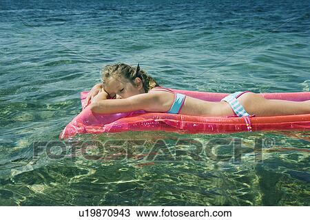Young girl sleeping floating on an inflatable raft. View Large Photo Image Stock Image - Young girl sleeping floating on an inflatable raft.. Fotosearch
