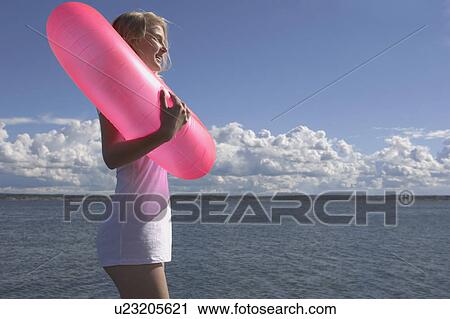 Stock Image - Young woman with swimming ring.. Fotosearch