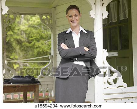 Picture - Businesswoman by country cottage. Fotosearch