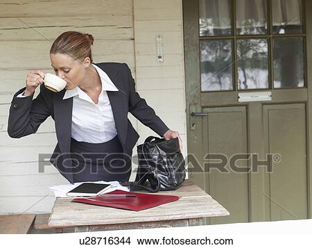 Businesswoman by country cottage leaving for work View Large Photo Image Picture - Businesswoman by country cottage leaving for work. Fotosearch