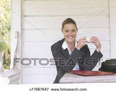 Businesswoman by country cottage with coffee View Large Photo Image Stock Photo - Businesswoman by country cottage with coffee. Fotosearch