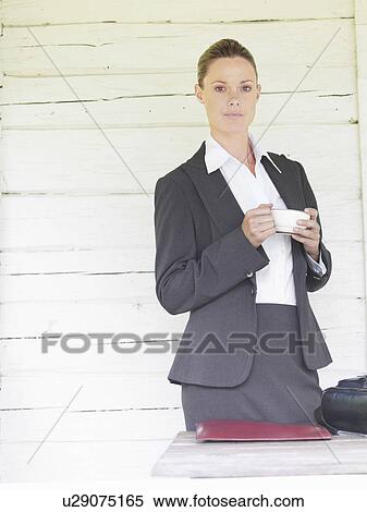 Businesswoman by country cottage with coffee View Large Photo Image Stock Photography - Businesswoman by country cottage with coffee. Fotosearch