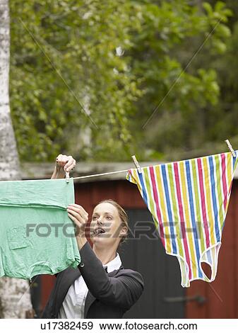 Businesswoman hanging washing up before going to work View Large Photo Image Stock Photo - Businesswoman hanging washing up before going to work. Fotosearch