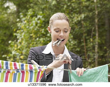 Businesswoman hanging washing up before going to work View Large Photo Image Stock Photograph - Businesswoman hanging washing up before going to work. Fotosearch