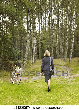 Businesswoman walking in woods View Large Photo Image Picture - Businesswoman walking in woods. Fotosearch