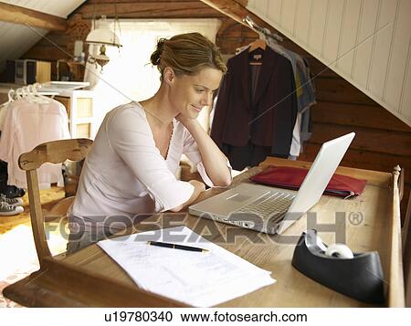 Stock Image - Businesswoman working from home office. Fotosearch