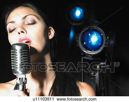 Close up of woman singing into microphone. View Large Photo Image Stock Image - Close up of woman singing into microphone.. Fotosearch