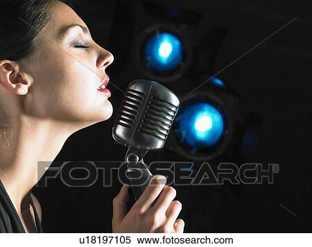 Female singer with microphone elegant black dress blue spots. View Large Photo Image Stock Photography - Female singer with microphone elegant black dress blue spots.. Fotosearch