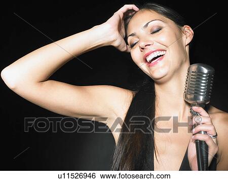 Woman laughing holding microphone. View Large Photo Image Stock Photograph - Woman laughing holding microphone.. Fotosearch