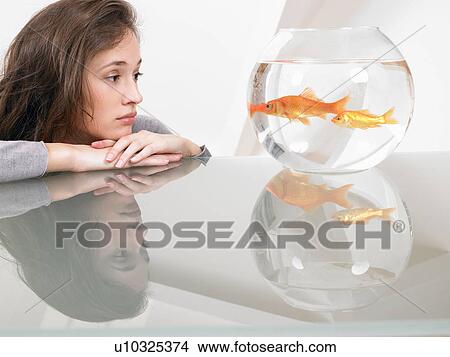 Woman looking at a goldfish View Large Photo Image Picture - Woman looking at a goldfish. Fotosearch
