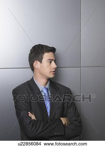 Businessman standing in front of a white wall View Large Photo Image Picture - Businessman standing in front of a white wall. Fotosearch