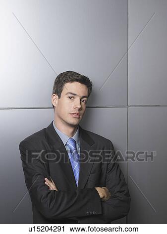 Businessman standing in front of a white wall View Large Photo Image Stock Image - Businessman standing in front of a white wall. Fotosearch