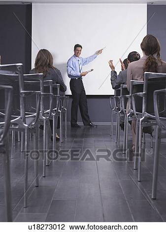 Stock Image - Man giving speech in presentation room. Fotosearch