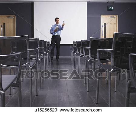Man practicing speech in empty presentation room View Large Photo Image Stock Photo - Man practicing speech in empty presentation room. Fotosearch