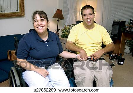 Stock Photo - A young couple, both with disabilities, holding hands with each other and enjoying being together.. Fotosearch