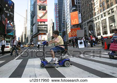 Boy using scooter to cross a street in New York City. View Large Photo Image Stock Image - Boy using scooter to cross a street in New York City.. Fotosearch