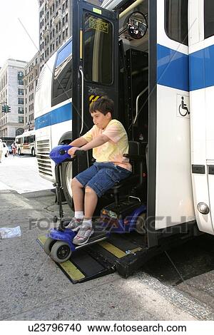 Boy with Muscular Dystrophy, utilizing a scooter/cart for mobility, exiting a city bus via a chair lift. View Large Photo Image Stock Image - Boy with Muscular Dystrophy, utilizing a scooter/cart for mobility, exiting a city bus via a chair lift.. Fotosearch