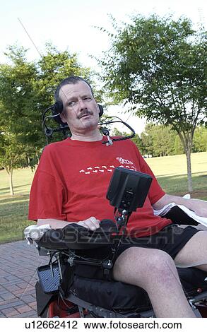 Stock Image - Image of a man with significant disabilities, including total body paralysis, experiencing life in the community with the assistance of technology that promotes independence.. Fotosearch