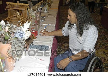 Man in wheelchair writing at a banquet table displaying arts and craft items. View Large Photo Image Stock Image - Man in wheelchair writing at a banquet table displaying arts and craft items.. Fotosearch