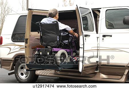 Man with a disability utilizing a powered wheelchair for mobility, entering his accessible van with the assistance of the van's lift. View Large Photo Image Picture - Man with a disability utilizing a powered wheelchair for mobility, entering his accessible van with the assistance of the van's lift.. Fotosearch