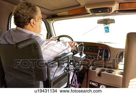 Man with a disability utilizing a powered wheelchair for mobility, driving his van that is powered with hand controls. View Large Photo Image Picture - Man with a disability utilizing a powered wheelchair for mobility, driving his van that is powered with hand controls.. Fotosearch